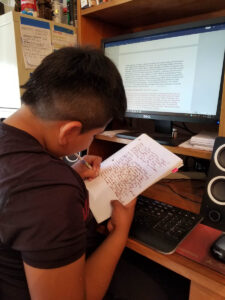 Native child works on a school paper.